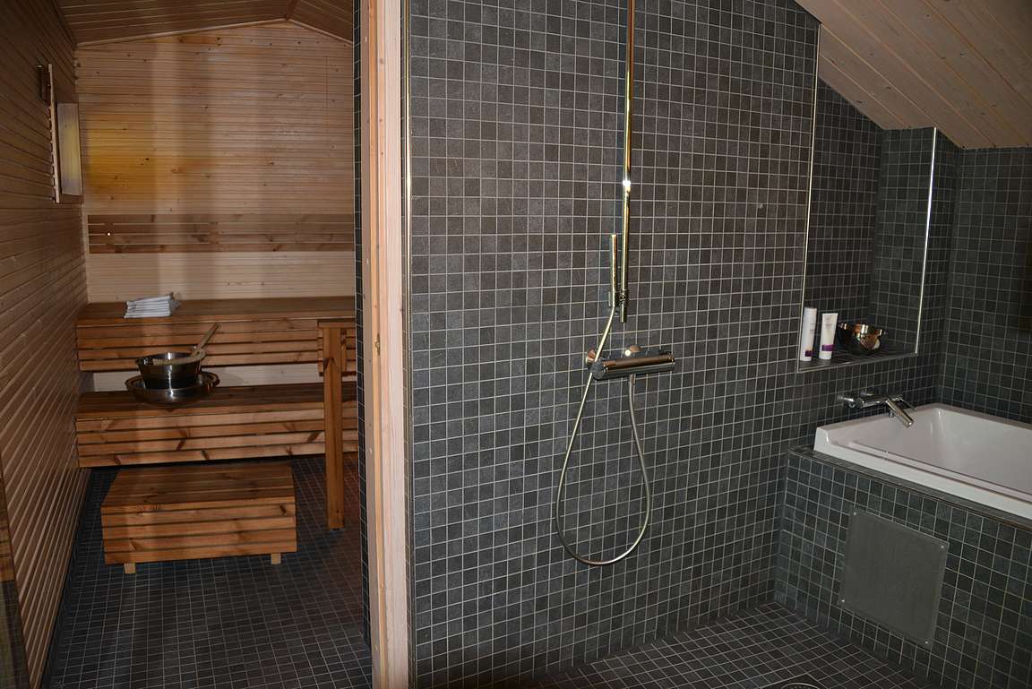 Pesutiloissa oli pari suihkua, kylpyamme ja taustalla näkyvä iso sauna.